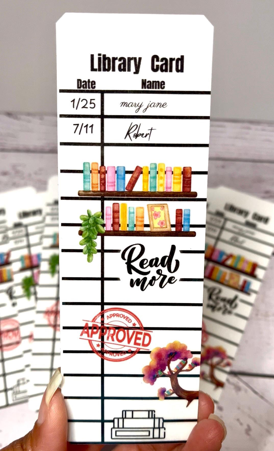 Library card with bookshelf design and 'Read more' text, held by a hand.