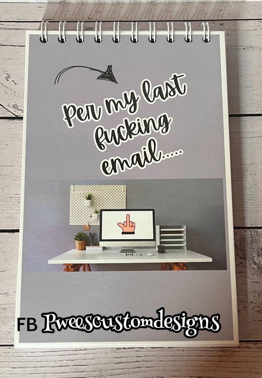 Notebook with a humorous message and computer graphic on a wooden surface