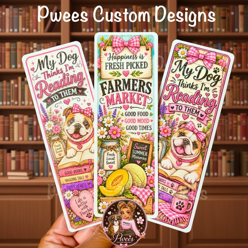 Three decorative bookmarks are shown being held by a hand against a warm brown background. The bookmarks feature colorful illustrations of a bulldog wearing a pink bow, flowers, books, and reading-themed text, including 'My Dog Thinks I'm Reading to Them' and 'Happiness is Fresh Picked'.