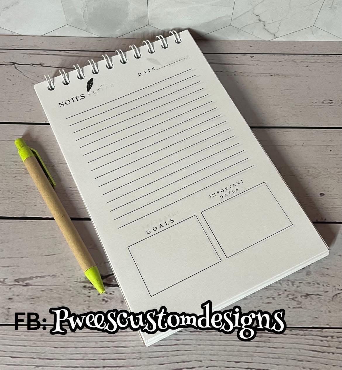 Notebook with a pen on a wooden surface, featuring sections for notes, goals, and important dates.