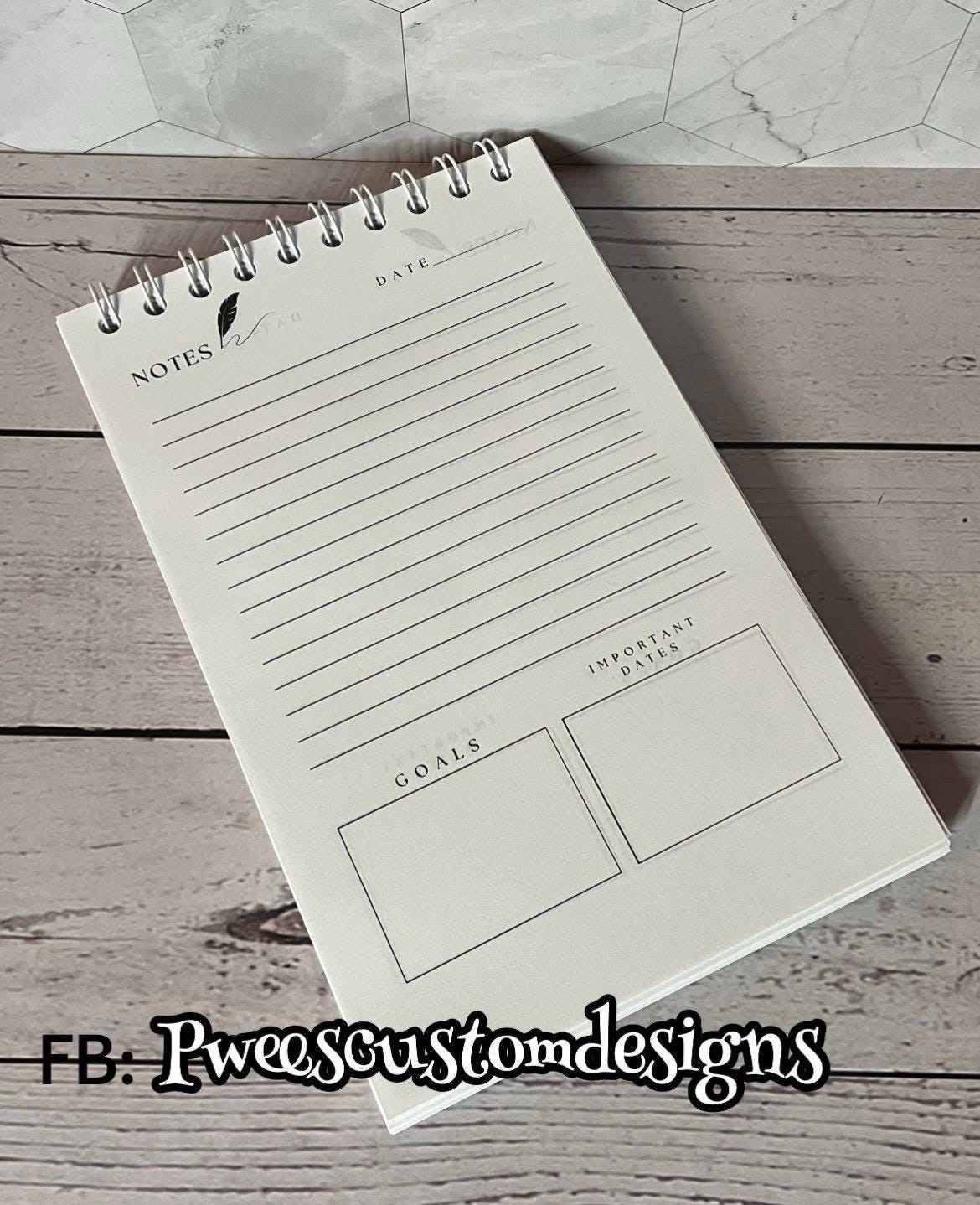 Notebook with pre-printed sections on a wooden surface, branded 'FB: Tweescustomdesigns'.